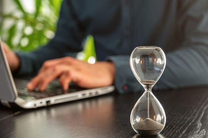 hourglass counting down next to laptop